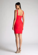 Back quarter image of model wearing a red bodycon mini dress, the dress features a square neck line. The dress featured is the Vesper Carly red mini dress