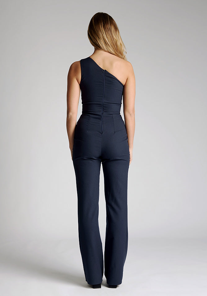 Back image of the model wearing a navy Jumpsuit with an asymmetric neckline, with a contrast satin band and wide leg finish a design features Vesper Georgie Navy Jumpsuit