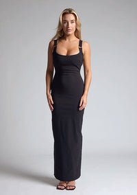Front image of a model wearing a black maxi dress, featuring metal detailing on the straps and a back strap detail. The dress featured is the Vesper Jessica black maxi dress