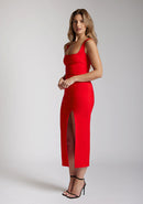 Front quarter image of a blonde model wearing a red bodycon midaxi dress with a square neckline with wide straps and a front skirt split. The design featured is the Vesper Abbie Red Bodycon Midaxi Dress