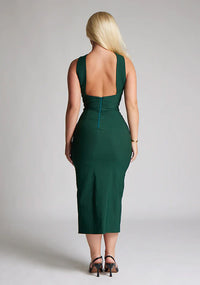Back image of blonde model wearing a forest green midaxi dress with a  flattering open back and ultra-sexy high leg split and a crossover neckline design. The design featured is the Vesper Aida Forest Green Cross Neck Midaxi Dress