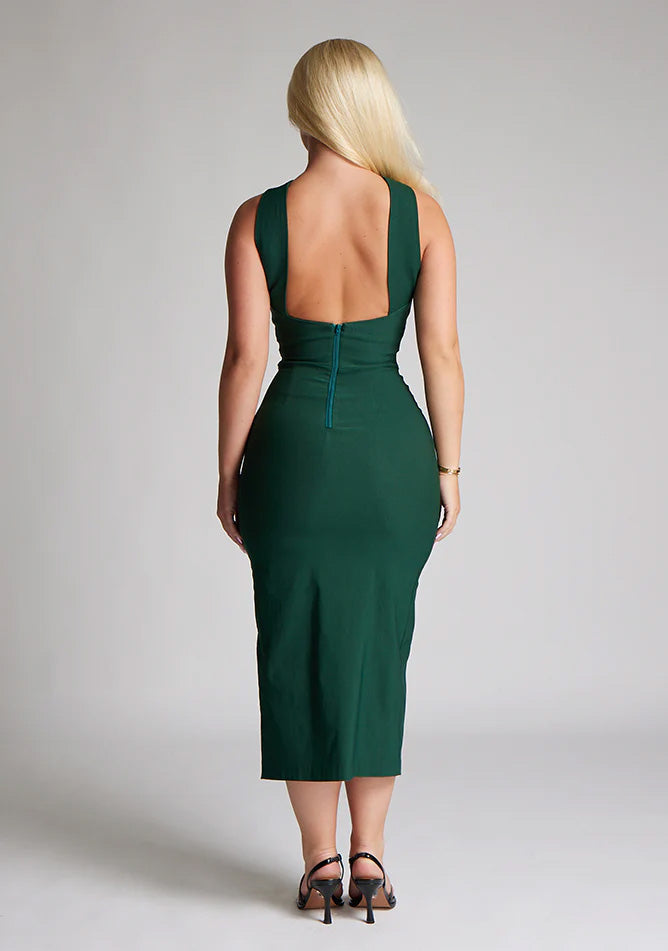 Back image of blonde model wearing a forest green midaxi dress with a  flattering open back and ultra-sexy high leg split and a crossover neckline design. The design featured is the Vesper Aida Forest Green Cross Neck Midaxi Dress