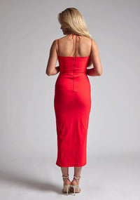 Back image of a blonde model wearing a red midaxi dress with a two alluring strappy designs, bodycon fit and a front skirt split. The design featured is the Vesper Alyssa Red Bodycon Midaxi Dress