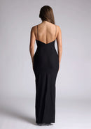 Back image of a of a model wearing a black maxi dress with a plunge neckline and bow detailing. The design featured is the Vesper Bellini Black Bow Maxi Dress