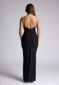 Back image of a of a model wearing a black maxi dress with a plunge neckline and bow detailing. The design featured is the Vesper Bellini Black Bow Maxi Dress