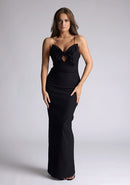 Front image of a model wearing a black maxi dress with a plunge neckline and bow detailing. The design featured is the Vesper Bellini Black Bow Maxi Dress