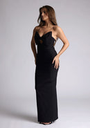 Front quarter image of a model wearing a black maxi dress with a plunge neckline and bow detailing. The design featured is the Vesper Bellini Black Bow Maxi Dress