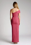 Back image of model wearing a raspberry maxi dress with a stunning one-sleeve off-shoulder design and an alluring front skirt split. The design featured is the Vesper Carmel Raspberry Maxi Dress