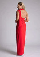 Back quarterimage of the model wearing a red scarf maxi dress with an asymmetric neckline, a front skirt split, and pleats at the front shoulder. The design featured is the Vesper Cordula Red Scarf Maxi Dress