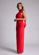 Front quarter image of the model wearing a red scarf maxi dress with an asymmetric neckline, a front skirt split, and pleats at the front shoulder. The design featured is the Vesper Cordula Red Scarf Maxi Dress