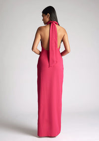 Back image of a model wearing a cerise maxi dress with a flattering halter neckline and with its eye-catching blue hue and a front skirt split. The design featured is the Vesper Davina Cerise Maxi Dress