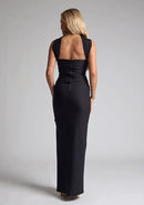 Back image of blonde model wearing a Black Collar Detail Maxi Dress with a  straight neckline and collar detailing at the neck, with straps at the back and a front skirt split, design features Vesper Dune Black Collar Detail Maxi Dress