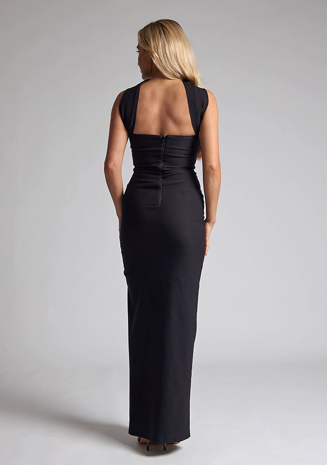 Back image of blonde model wearing a Black Collar Detail Maxi Dress with a  straight neckline and collar detailing at the neck, with straps at the back and a front skirt split, design features Vesper Dune Black Collar Detail Maxi Dress