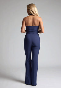Back image of a  model wearing a nany waistcoat with a chic, sophisticated and sleeveless halter-neck waistcoat top. The design featured is the Vesper Eve Navy Waistcoat paired with Vesper Connie Navy Wide Leg Trousers