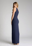 Back quarter image of model wearing a One-Shoulder Navy Maxi Dress with an asymmetric neckline and a daring thigh-high leg slit, and a front cut-out. The design features the Vesper Fliss One Shoulder Navy Maxi Dress.