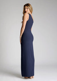 Back quarter image of model wearing a One-Shoulder Navy Maxi Dress with an asymmetric neckline and a daring thigh-high leg slit, and a front cut-out. The design features the Vesper Fliss One Shoulder Navy Maxi Dress.