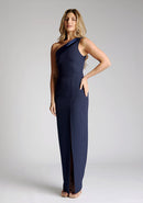 Front quarter image of model wearing a One-Shoulder Navy Maxi Dress with an asymmetric neckline and a daring thigh-high leg slit, and a front cut-out. The design features the Vesper Fliss One Shoulder Navy Maxi Dress.