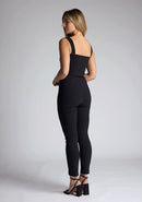 Back quarter image of the model wearing pine green top with a sweetheart neckline and wide straps create a flattering silhouette, while the circular cut outs at the hem add a touch of edge and statement front zip. The design featured is the Vesper Juno Black Crop Top paired with Vesper Raven Black High Waist Trousers