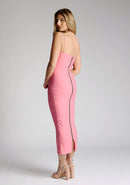 Back quarter image of blonde model wearing a forest green midaxi dress with a alluring asymmetric design flatters every figure, while the bodycon silhouette accentuates your natural curves. The design featured is the Vesper Landen Fiesta Pink Dress