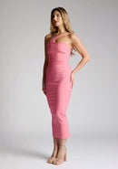 Front quarter image of blonde model wearing a forest green midaxi dress with a alluring asymmetric design flatters every figure, while the bodycon silhouette accentuates your natural curves. The design featured is the Vesper Landen Fiesta Pink Dress
