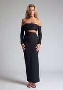 Front image of a blonde model wearing a black maxi dress with a strapless design, off-shoulder design, and a stylish side cut-out, the design features Vesper Leena Black Maxi Dress