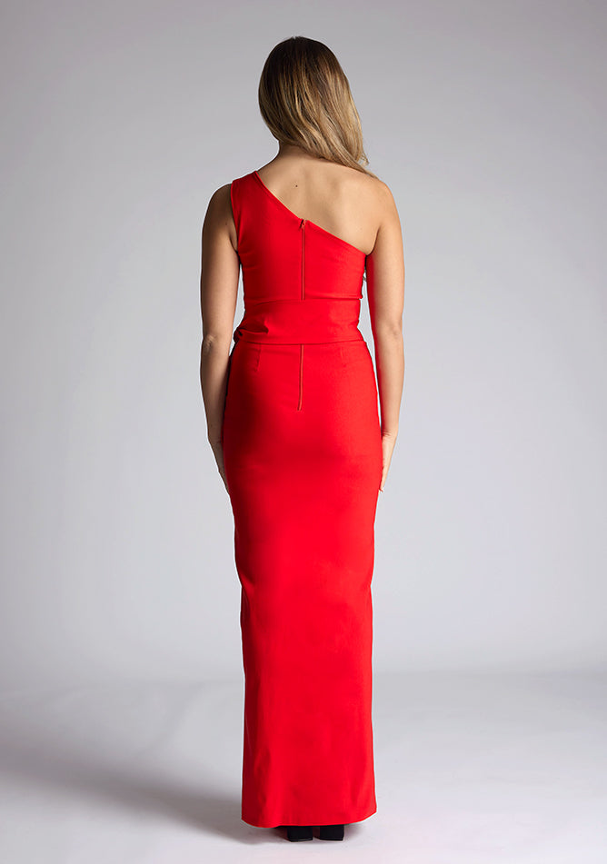 Back image of the model wearing an red maxi dress with a sleeveless stunner boasts an asymmetric design and a flattering wrap belt and front skirt split. The design featured is the Vesper Lisbeth Red Maxi Dress