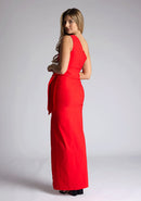 Back quarter image of the model wearing an red maxi dress with a sleeveless stunner boasts an asymmetric design and a flattering wrap belt and front skirt split. The design featured is the Vesper Lisbeth Red Maxi Dress