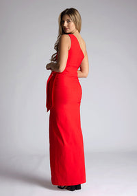 Back quarter image of the model wearing an red maxi dress with a sleeveless stunner boasts an asymmetric design and a flattering wrap belt and front skirt split. The design featured is the Vesper Lisbeth Red Maxi Dress