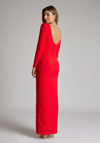 Back quarter image of a model wearing a red maxi dress with long sleeves, front skirt split and a low back. The design featured is the Vesper Mandy Red Long Sleeve Maxi Dress