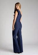 Back quarter image of the model wearing a navy one shoulder jumpsuit
with a asymmetric neckline and one shoulder with a ruffle detail and wide leg finish elongates your silhouette, while the centre back zip ensures a sleek fit. The design featured is the Vesper Monty Navy One Shoulder Jumpsuit