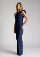 Front quarter image of the model wearing a navy one shoulder jumpsuit
with a asymmetric neckline and one shoulder with a ruffle detail and wide leg finish elongates your silhouette, while the centre back zip ensures a sleek fit. The design featured is the Vesper Monty Navy One Shoulder Jumpsuit