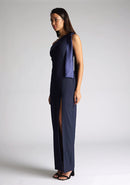 Front quarter image of a model wearing a  One Shoulder Navy Maxi Dress with a  one shoulder contrast satin band and bow detail with a front skirt split. The design features Vesper Olympia One Shoulder Navy Maxi Dress