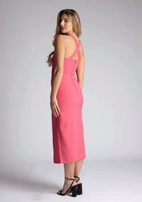 Back quarter image of model wearing a pink sweetheart midaxi dress with a plunge sweetheart neckline with wide straps that cross at the back and a front skirt split. The design featured is the Vesper Poppy Pink Sweetheart Midaxi Dress