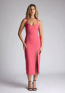 Front image of model wearing a pink sweetheart midaxi dress with a plunge sweetheart neckline with wide straps that cross at the back and a front skirt split. The design featured is the Vesper Poppy Pink Sweetheart Midaxi Dress