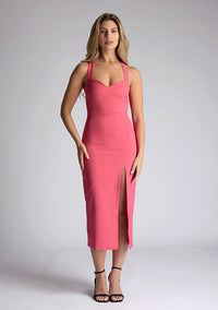 Front image of model wearing a pink sweetheart midaxi dress with a plunge sweetheart neckline with wide straps that cross at the back and a front skirt split. The design featured is the Vesper Poppy Pink Sweetheart Midaxi Dress
