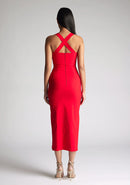 Back image of a  model wearing a red midaxi dress, featuring plunge sweetheart halter neck straps which cross at the back and a front skirt split. The dress featured is the Vesper Poppy Red Sweetheart Midaxi Dress