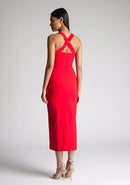 Back quarter image of a  model wearing a red midaxi dress, featuring plunge sweetheart halter neck straps which cross at the back and a front skirt split. The dress featured is the Vesper Poppy Red Sweetheart Midaxi Dress