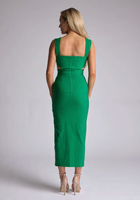 Back image of a model wearing a green cut out midaxi dress with a sweetheart neckline with wide straps, a side cut-out and front skirt split. The design featured is the Vesper Porticini Emerald Green Cut Out Midaxi Dress
