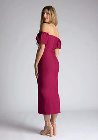 Back quarter image of a blonde model wearing a berry midaxi dress with a bardot neckline gracefully frame off shoulders, while the back zip ensures a seamless silhouette. The dress  features is the Vesper Quinton Berry Midaxi Dress