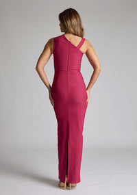 Back image of a model wearing a raspberry asymmetric maxi dress with a asymmetric neckline silhouette, back skirt split and ruched detailing enhances the dress's allure. The design featured is the Vesper Wyatt Raspberry Asymmetric Maxi Dress