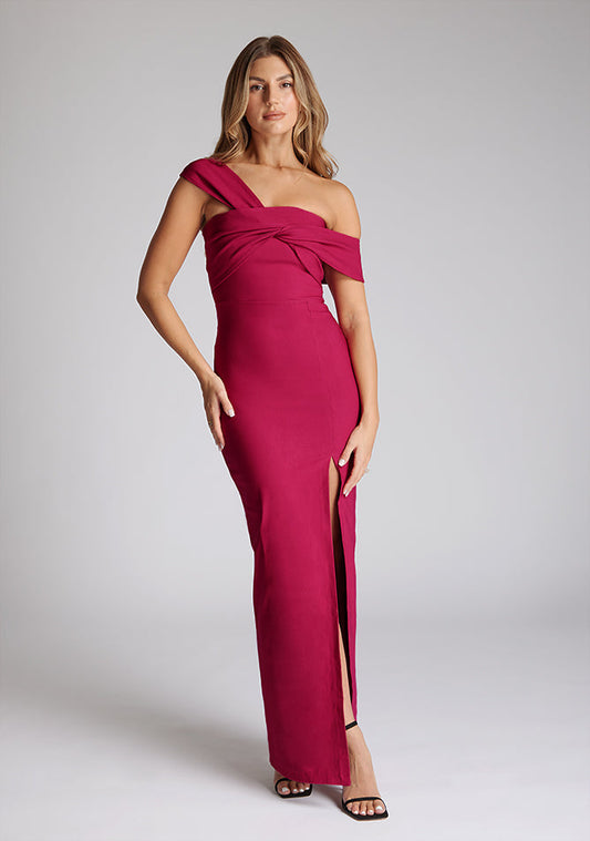 Front image of blonde model wearing a Raspberry Maxi Dress with a asymmetrical silhouette, front skirt split and a bodycon fit, a design features Vesper Winslow Raspberry Maxi Dress